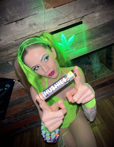 A woman holding up a chocolate bar with marijuana leaves on it.